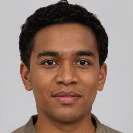 Joyful black young-adult male with short  black hair and brown eyes