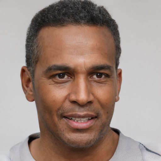 Joyful latino adult male with short  brown hair and brown eyes