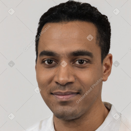 Joyful black young-adult male with short  black hair and brown eyes
