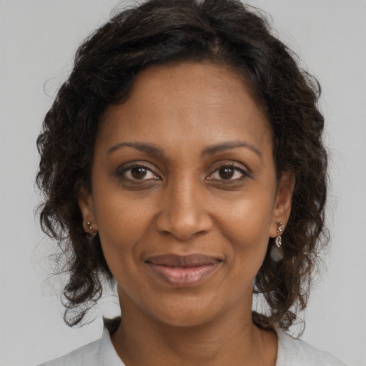 Joyful black adult female with medium  brown hair and brown eyes
