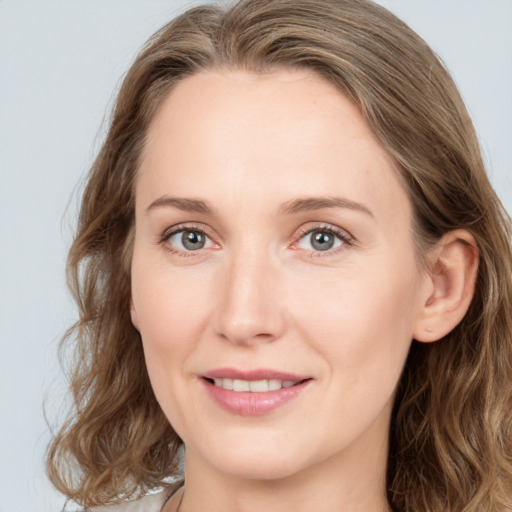 Joyful white young-adult female with long  brown hair and blue eyes