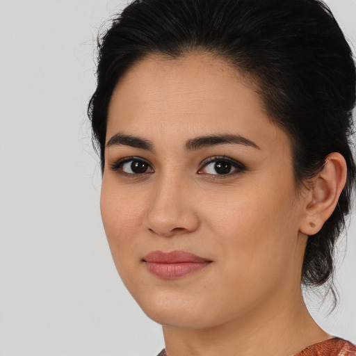 Joyful latino young-adult female with medium  brown hair and brown eyes
