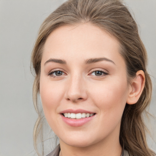 Joyful white young-adult female with medium  brown hair and grey eyes