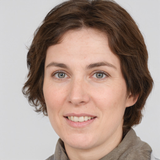 Joyful white adult female with medium  brown hair and grey eyes