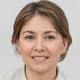 Joyful white adult female with medium  brown hair and brown eyes