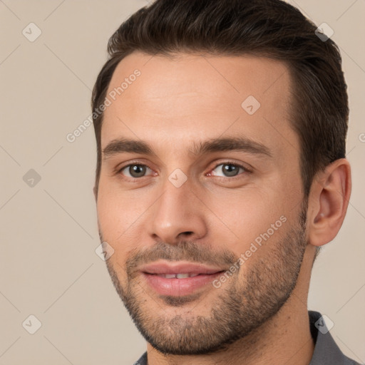 Joyful white young-adult male with short  brown hair and brown eyes