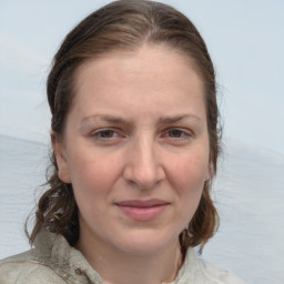 Joyful white adult female with medium  brown hair and blue eyes