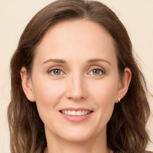 Joyful white young-adult female with long  brown hair and grey eyes