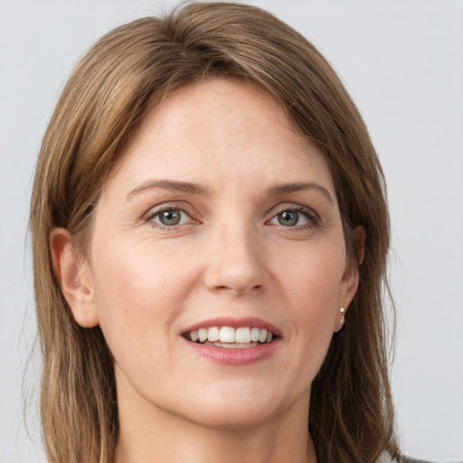 Joyful white young-adult female with long  brown hair and grey eyes