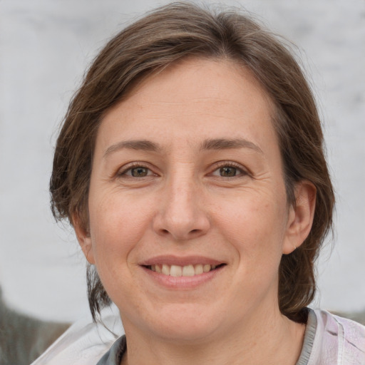 Joyful white adult female with medium  brown hair and grey eyes