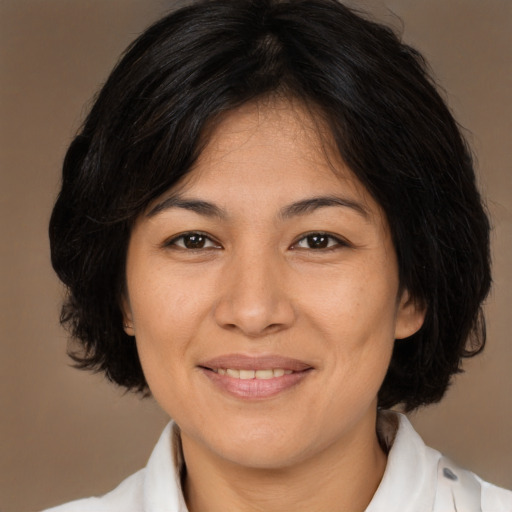 Joyful latino adult female with medium  brown hair and brown eyes