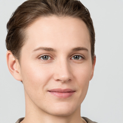 Joyful white young-adult female with short  brown hair and grey eyes