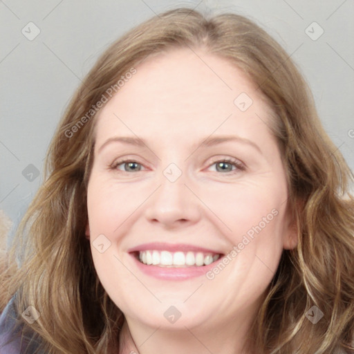 Joyful white adult female with long  brown hair and blue eyes