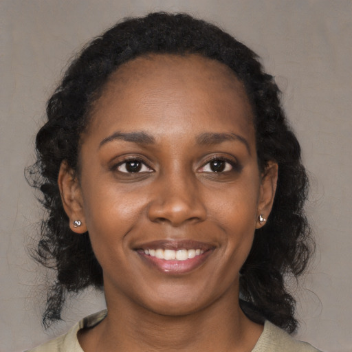 Joyful black young-adult female with medium  black hair and brown eyes