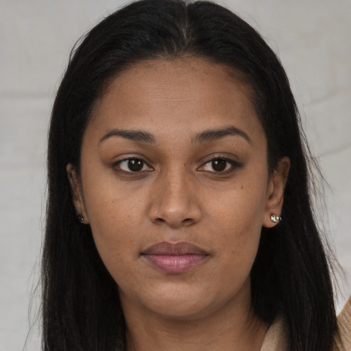 Joyful black young-adult female with long  brown hair and brown eyes