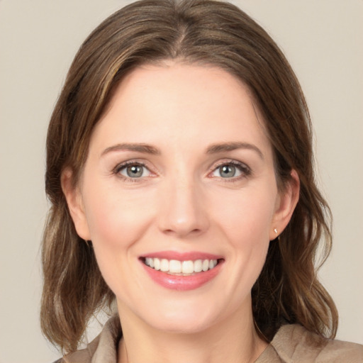 Joyful white young-adult female with medium  brown hair and green eyes