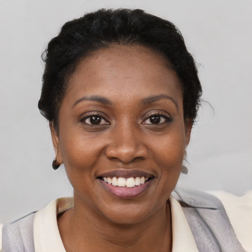 Joyful black young-adult female with short  brown hair and brown eyes