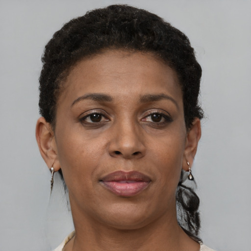 Joyful black adult female with short  brown hair and brown eyes