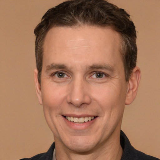 Joyful white adult male with short  brown hair and brown eyes