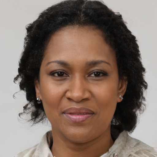 Joyful black adult female with medium  brown hair and brown eyes