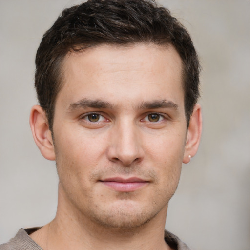 Joyful white young-adult male with short  brown hair and grey eyes