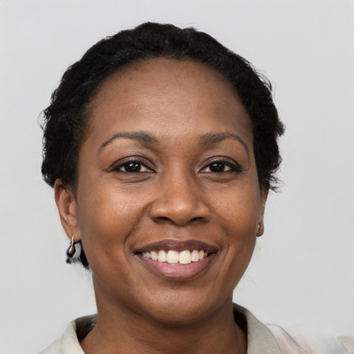 Joyful black young-adult female with short  black hair and brown eyes