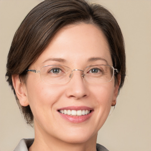 Joyful white adult female with medium  brown hair and grey eyes