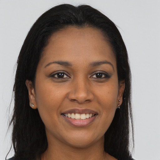 Joyful black young-adult female with long  brown hair and brown eyes