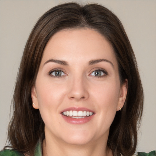 Joyful white young-adult female with medium  brown hair and green eyes