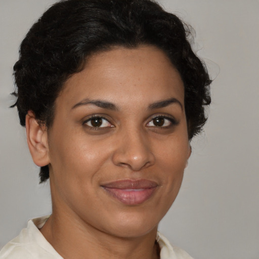 Joyful black young-adult female with short  brown hair and brown eyes