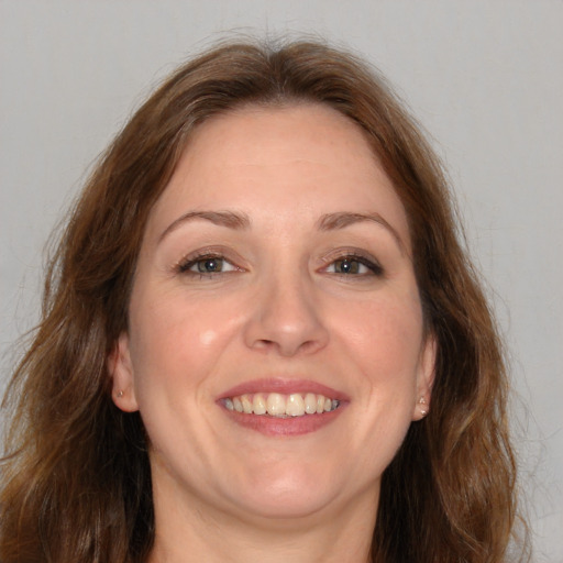 Joyful white adult female with long  brown hair and brown eyes