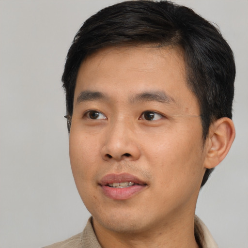 Joyful asian young-adult male with short  black hair and brown eyes