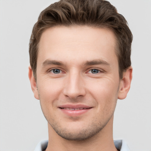 Joyful white young-adult male with short  brown hair and grey eyes