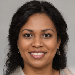 Joyful black young-adult female with long  brown hair and brown eyes