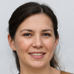 Joyful white adult female with medium  brown hair and brown eyes