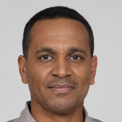 Joyful black adult male with short  black hair and brown eyes