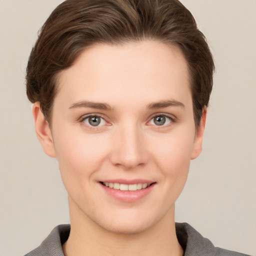 Joyful white young-adult female with short  brown hair and grey eyes