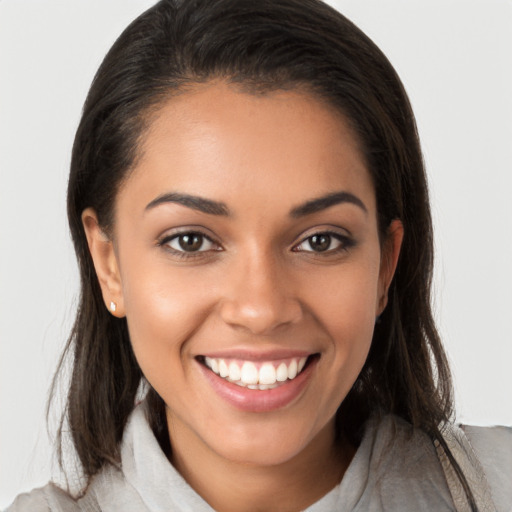 Joyful latino young-adult female with medium  brown hair and brown eyes