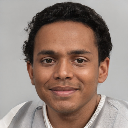 Joyful black young-adult male with short  black hair and brown eyes