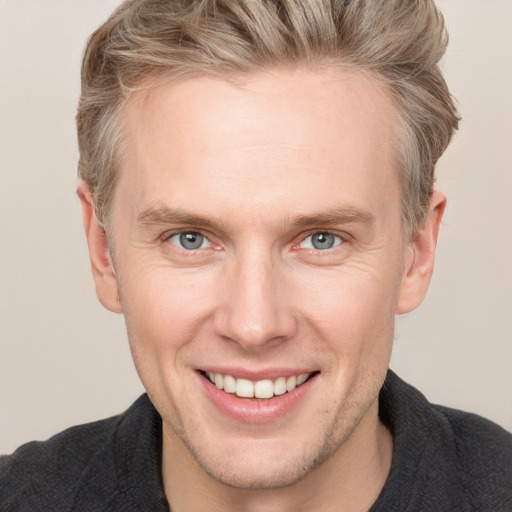 Joyful white adult male with short  brown hair and blue eyes