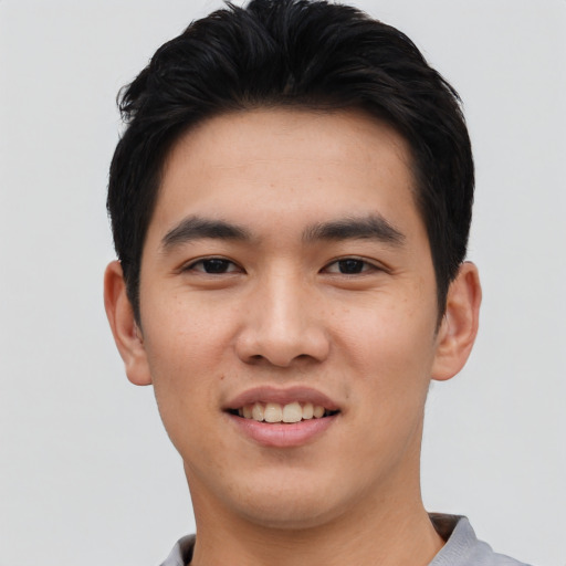 Joyful asian young-adult male with short  black hair and brown eyes