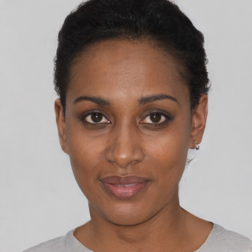 Joyful black young-adult female with short  black hair and brown eyes