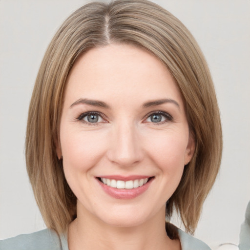 Joyful white young-adult female with medium  brown hair and green eyes