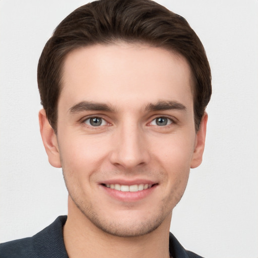 Joyful white young-adult male with short  brown hair and grey eyes