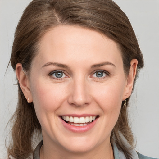 Joyful white young-adult female with medium  brown hair and blue eyes