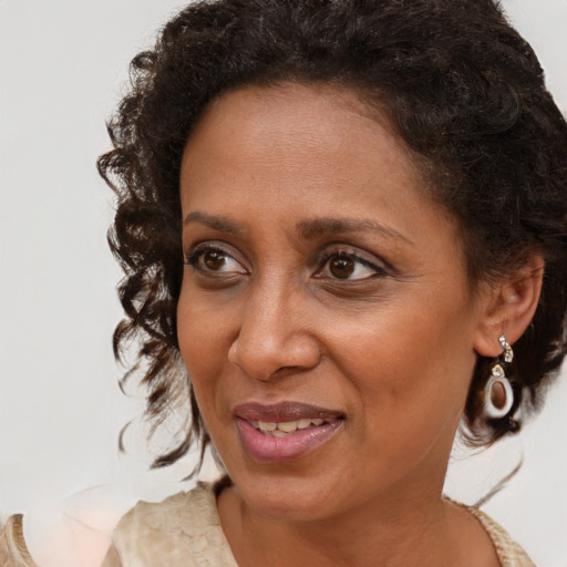 Joyful black adult female with medium  brown hair and brown eyes
