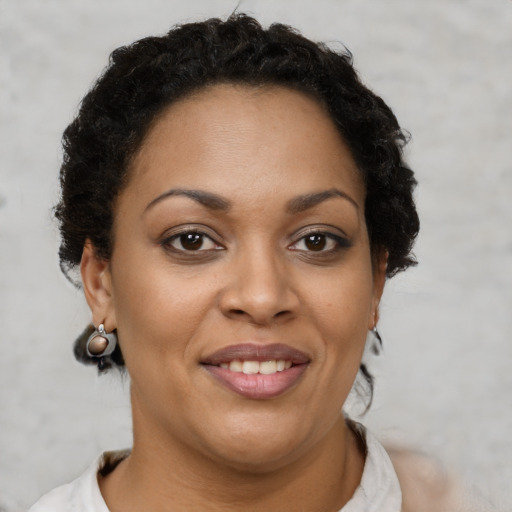 Joyful black adult female with short  brown hair and brown eyes
