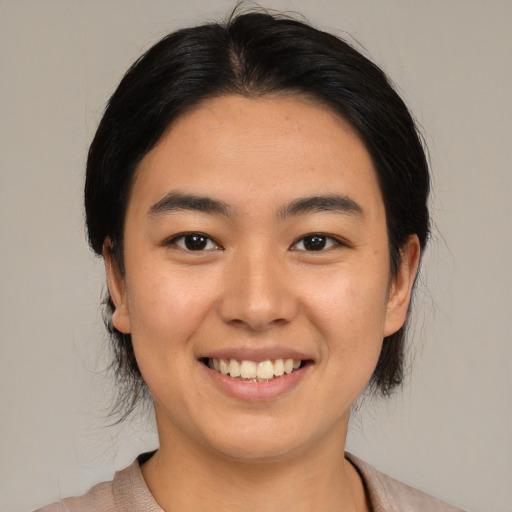 Joyful asian young-adult female with medium  black hair and brown eyes