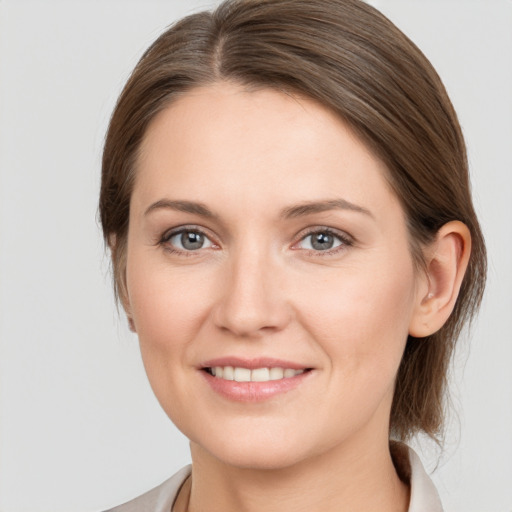 Joyful white young-adult female with medium  brown hair and grey eyes