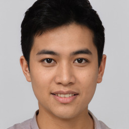 Joyful asian young-adult male with short  black hair and brown eyes